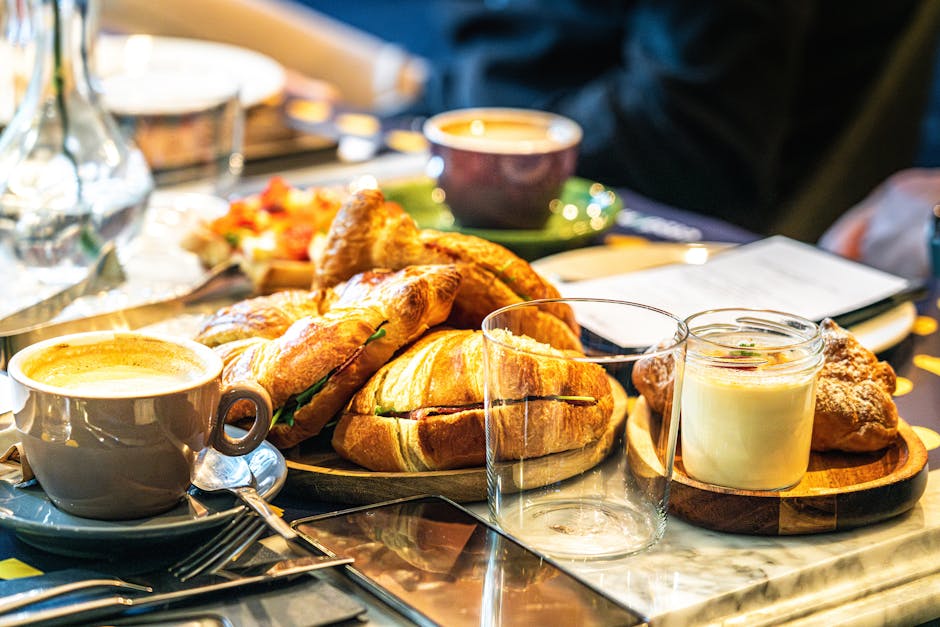 A breakfast spread of fresh croissants and coffee in warm morning light.